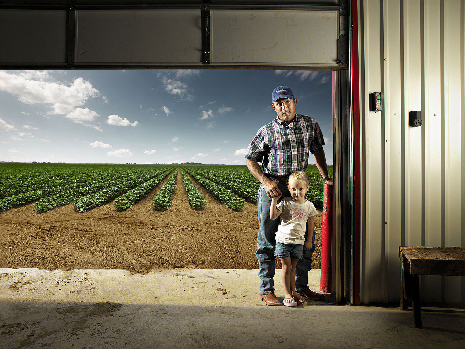 Father daughter portrait in steel shed doorway.