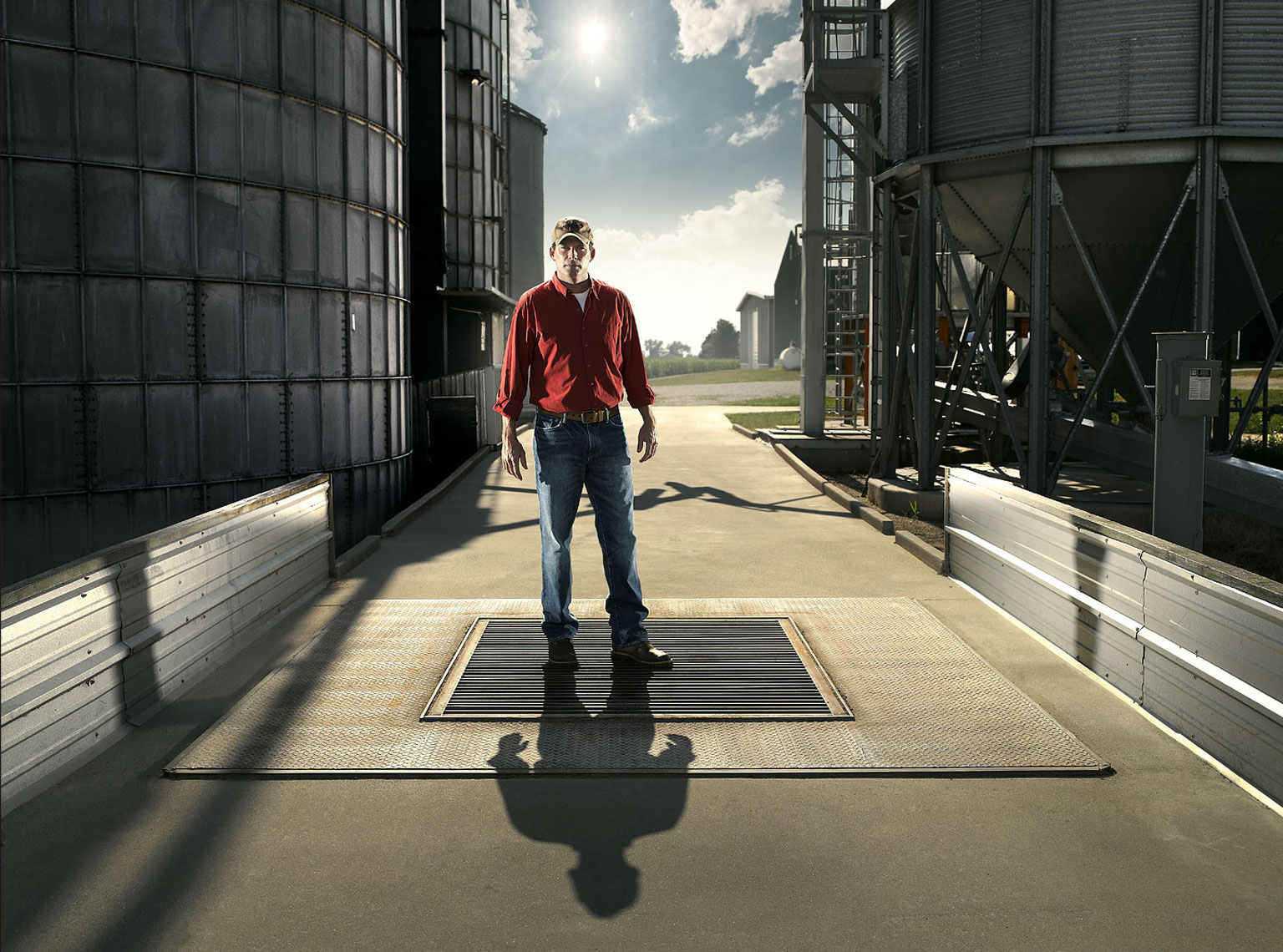 Corn and soybean farmer standing under his grain elevator.