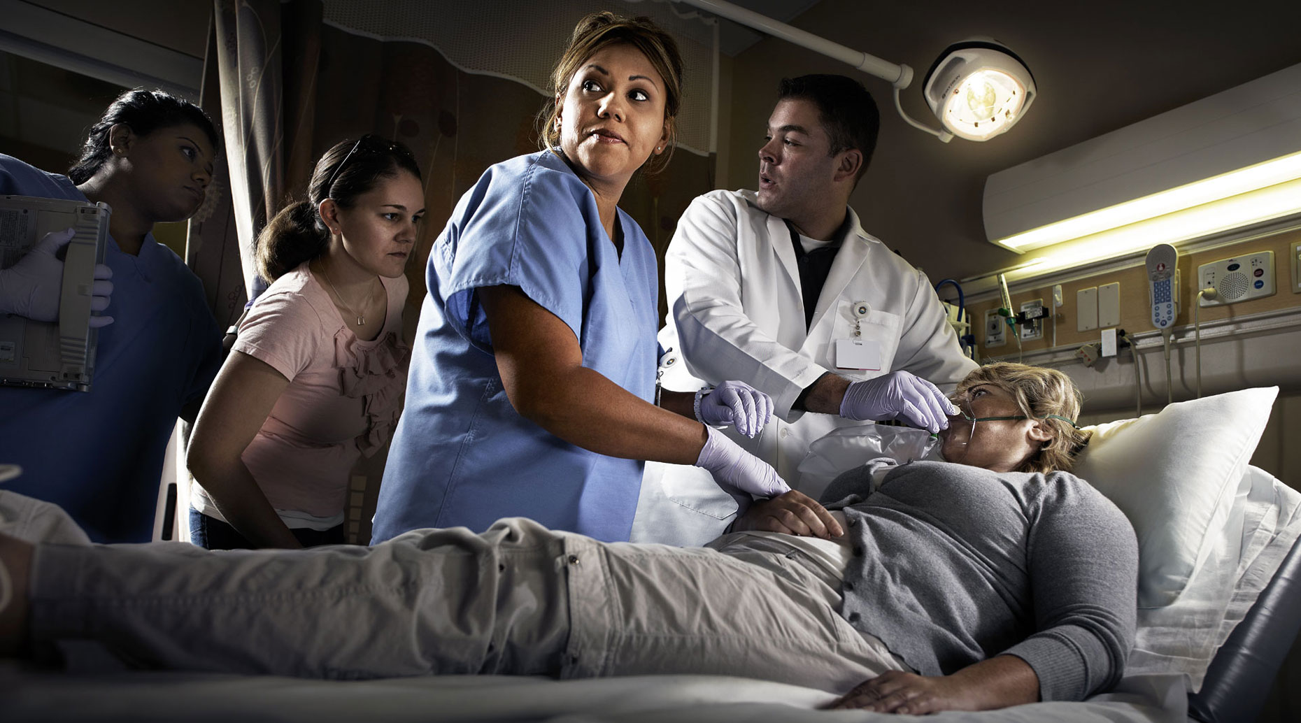 Nurse doctor patient and family in an ER room.